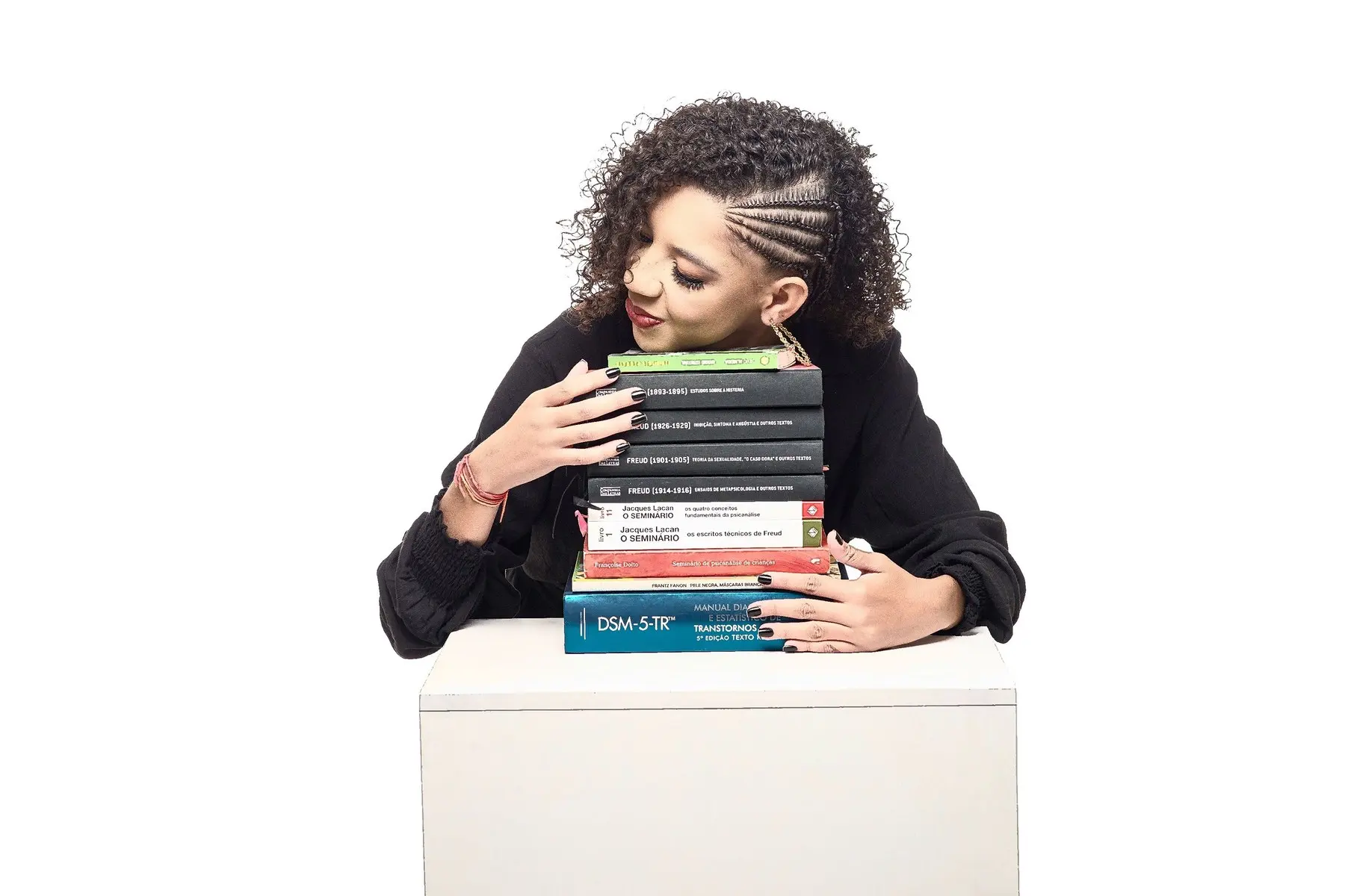 Layse abraçada a uma pilha de livros